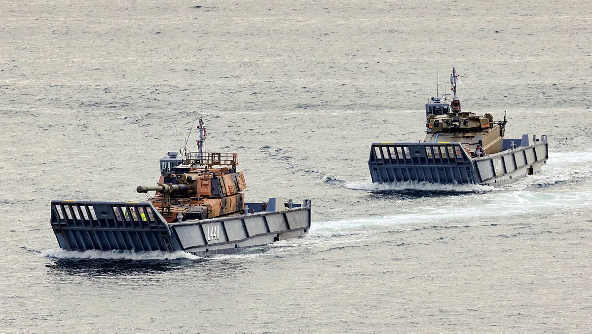 An AS9 Huntsman self-propelled howitzer and an AS21 Redback infantry fighting vehicle are transported on Navy LCM-1E landing craft during sea trials at Garden Island, Sydney Harbour.