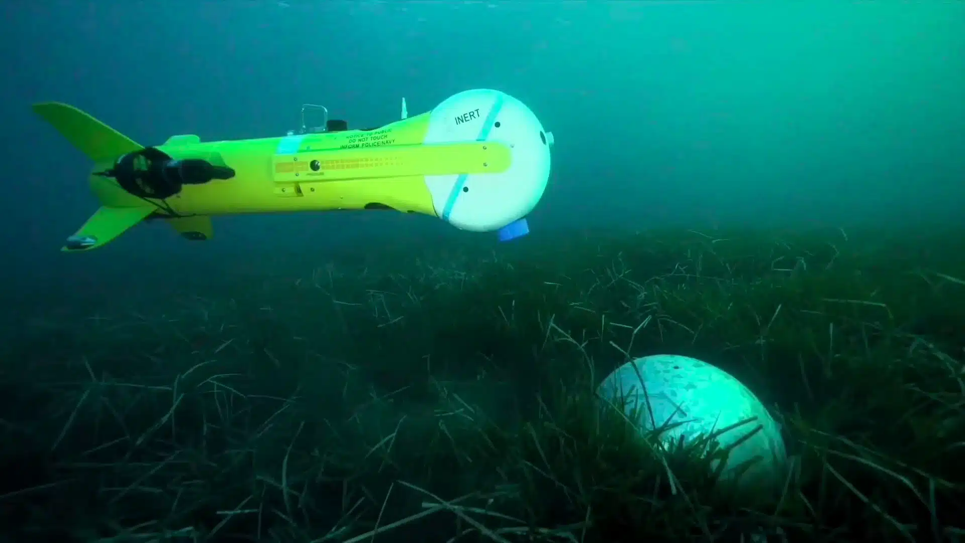 K-Ster C lightweight expandable underwater mine disposal vehicle underwater inspecting a mine-like object.