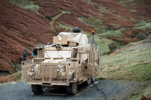 A British Army Wolfhound protected mobility vehicle equipped with a high-energy laser directed-energy weapon demonstrator undergoes trials, serving as a technological precursor to Project PANOPTES.