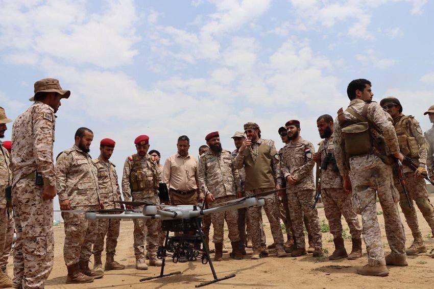 Service members of the Yemeni Armed Forces inspect an unmanned aerial vehicle.