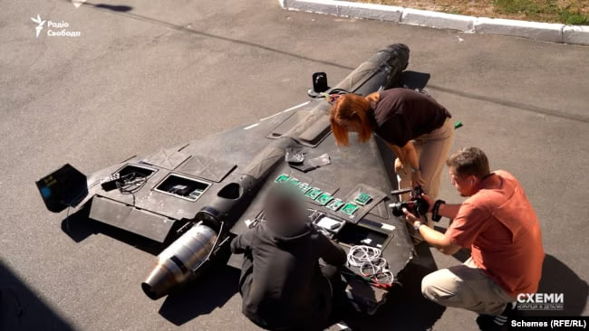 Ukrainian specialists and a Schemes journalist beside an intact Russian Geran-4 drone.